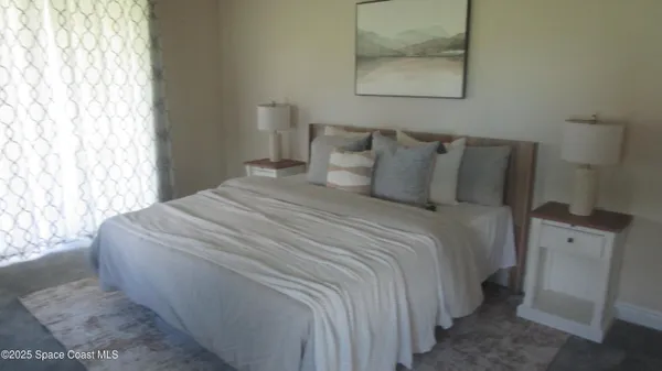 a bedroom with a bed and painting on the wall