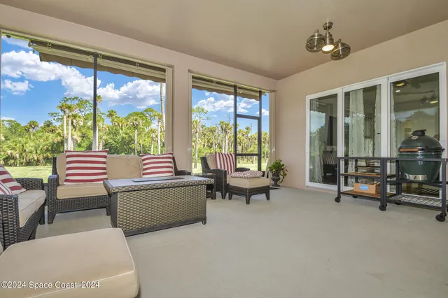 a living room with furniture and floor to ceiling windows