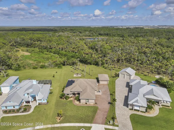 an aerial view of residential houses with outdoor space and a lake view