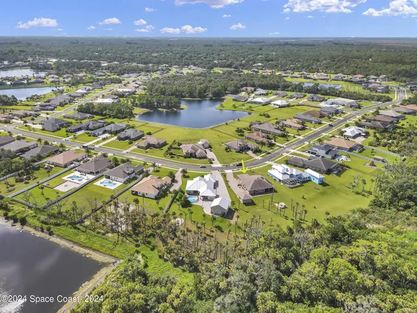 an aerial view of residential houses with outdoor space and swimming pool