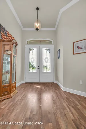a view of an empty room with window and wooden floor