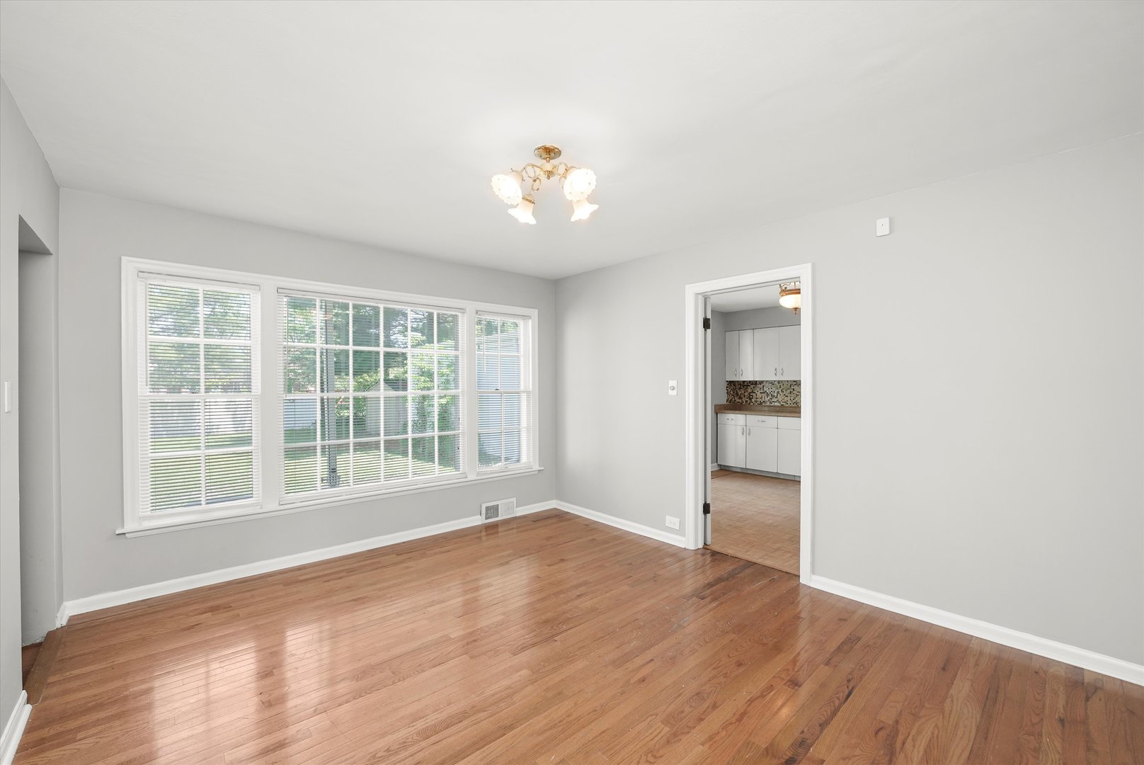255 Irving Boulevard Chicago Heights, IL 60411 - Photo 9 of 42 an empty room with wooden floor and windows