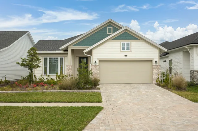 a front view of a house with a garden and yard