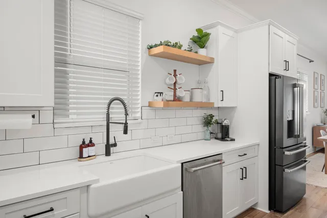 a kitchen with white cabinets and white appliances