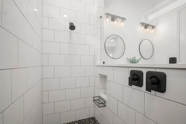 a bathroom with a double vanity sink a toilet and a mirror