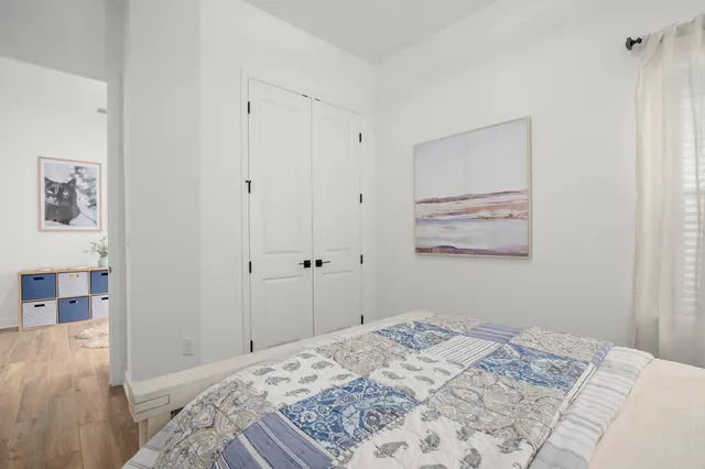 a bedroom with a bed and a painting on the wall