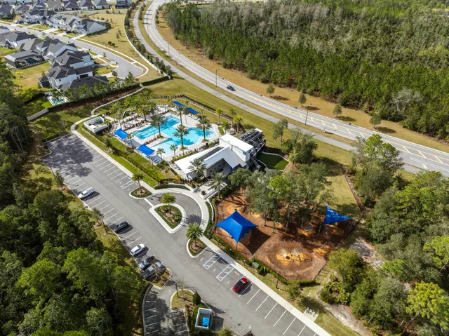 an aerial view of residential houses with outdoor space and swimming pool