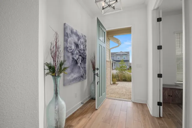 a view of a hallway with wooden floor and front door