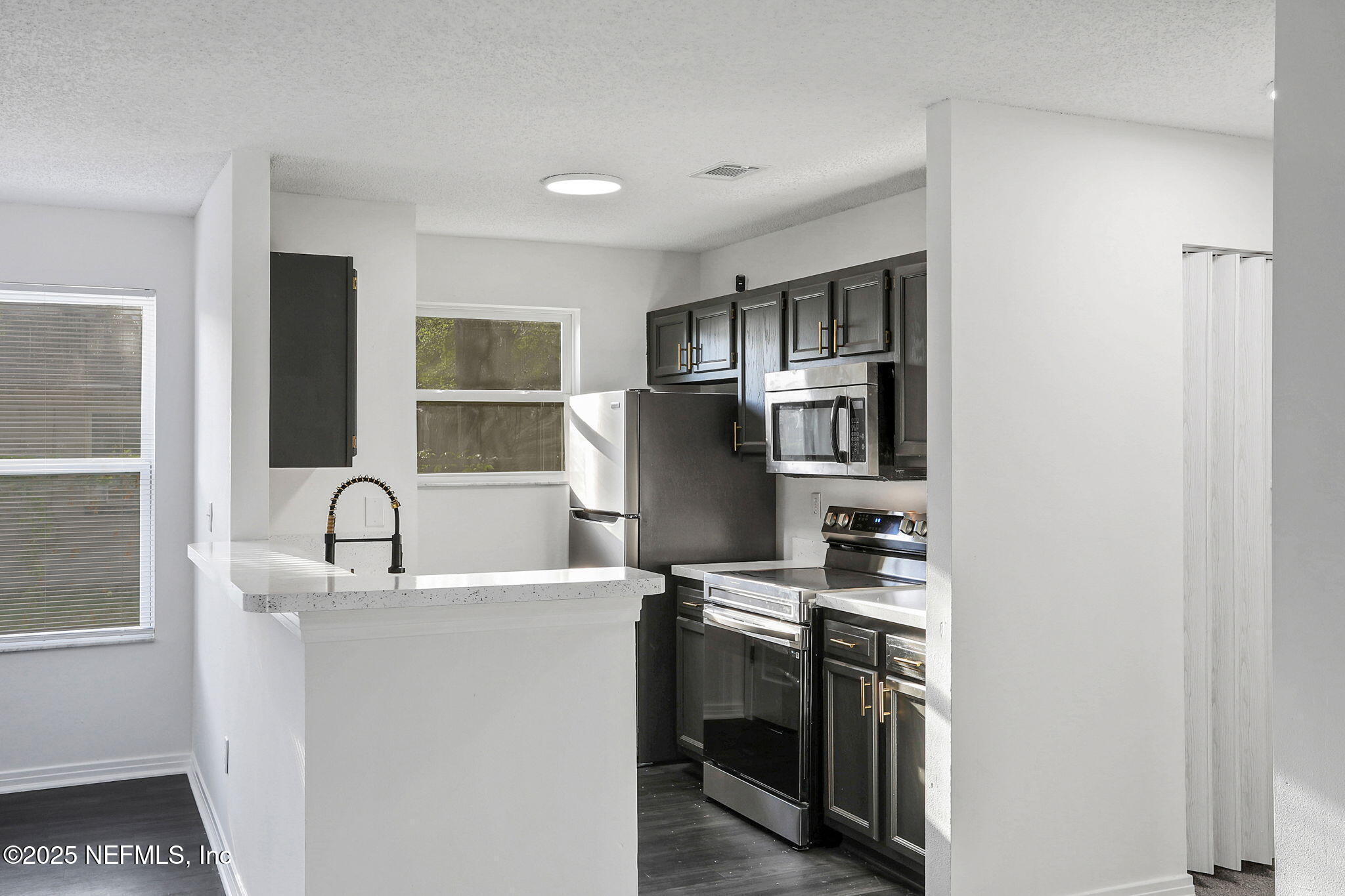 2122 Brooklyn Road Jacksonville, FL 32209 - Photo 3 of 19 a kitchen with stainless steel appliances granite countertop a sink and cabinets