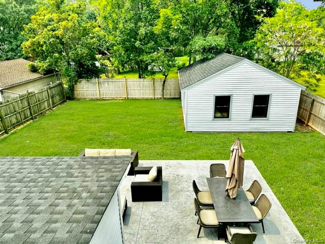 275 Sound Road Greenport, NY 11944 - Photo 8 of 33 Fenced backyard with an outbuilding, a patio, and view of scattered trees