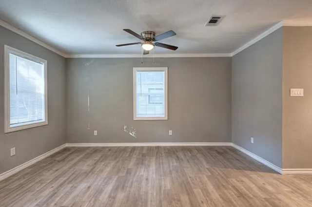 a view of room with window ceiling fan and hardwood floor