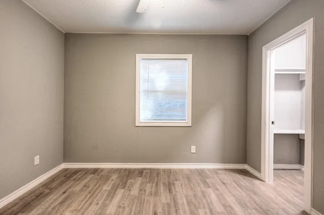 an empty room with wooden floor and a window