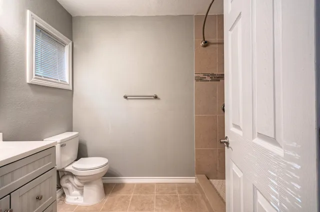 a bathroom with a toilet and a shower