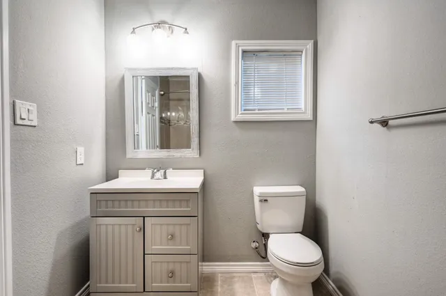 a bathroom with a toilet sink and mirror
