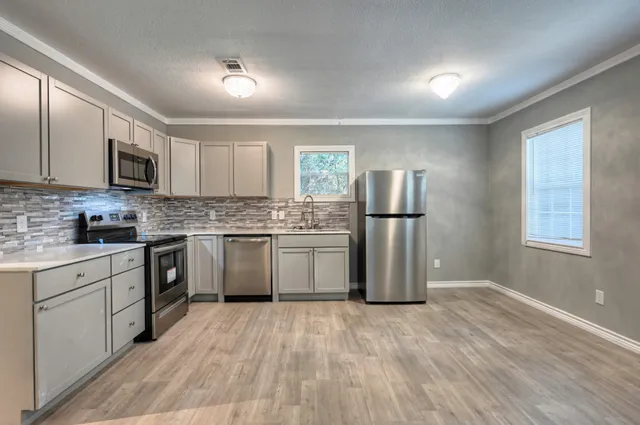 a kitchen with stainless steel appliances granite countertop a refrigerator sink and microwave