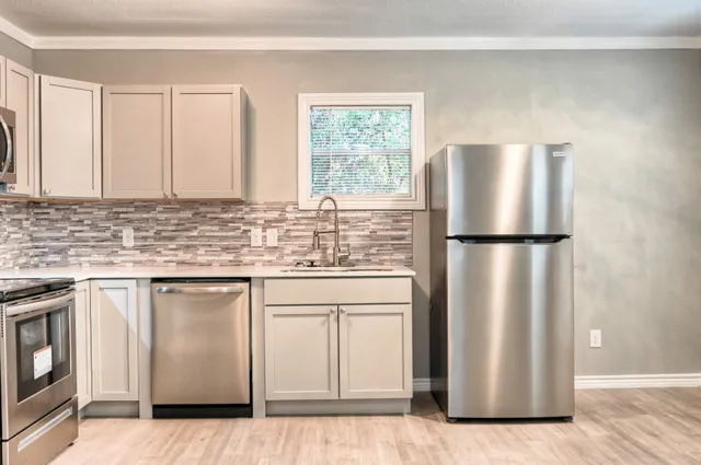 a kitchen with stainless steel appliances granite countertop a refrigerator sink and cabinets