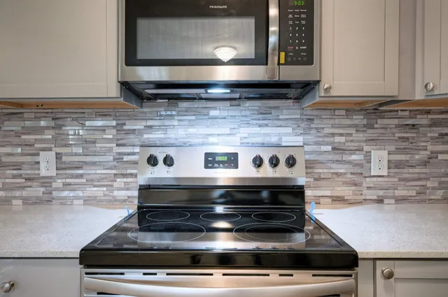 a stove top oven sitting inside of a kitchen