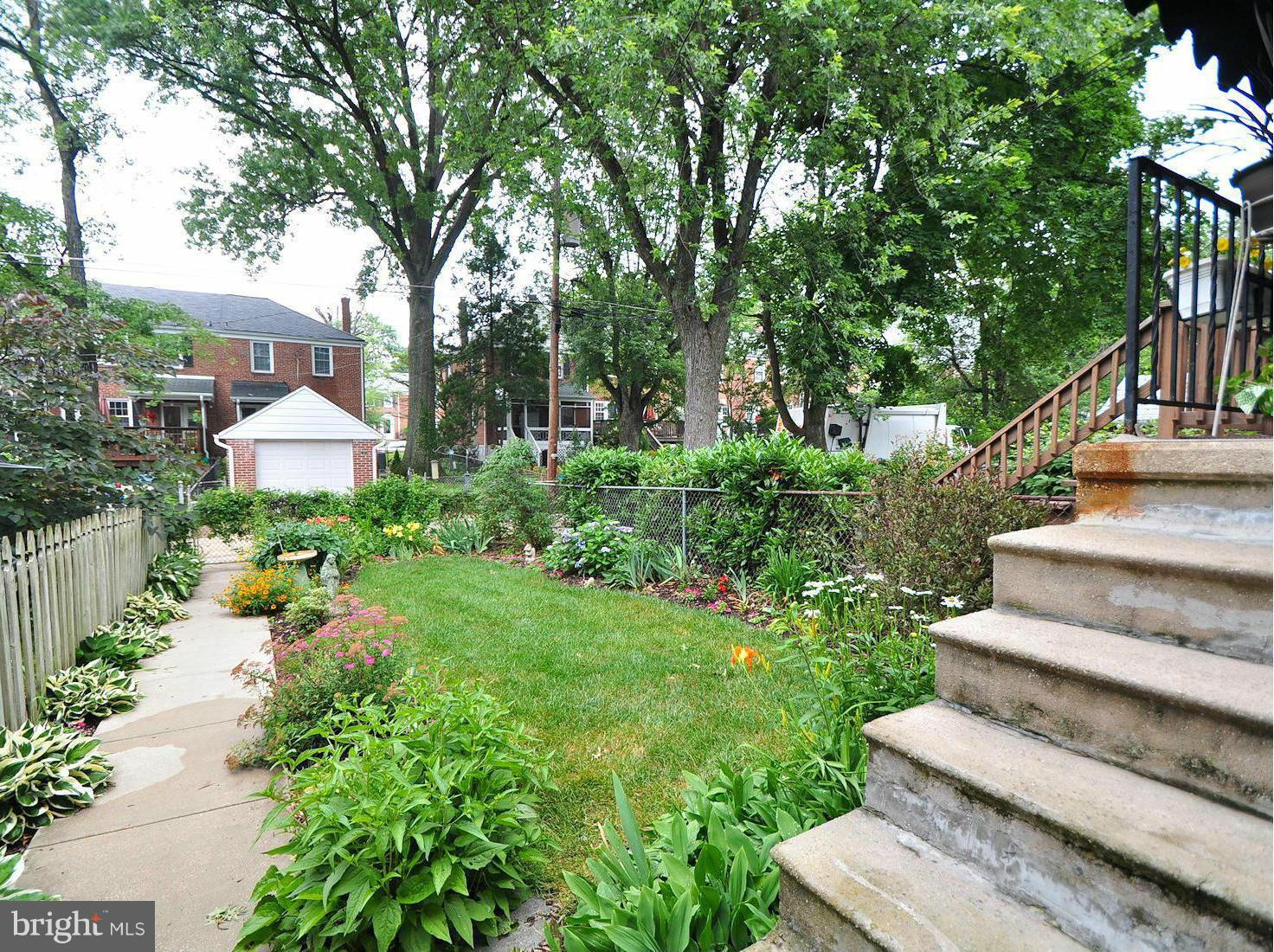 104 Overbrook Road Baltimore, MD 21212 - Photo 25 of 27 a view of a garden with lawn chairs and a large tree