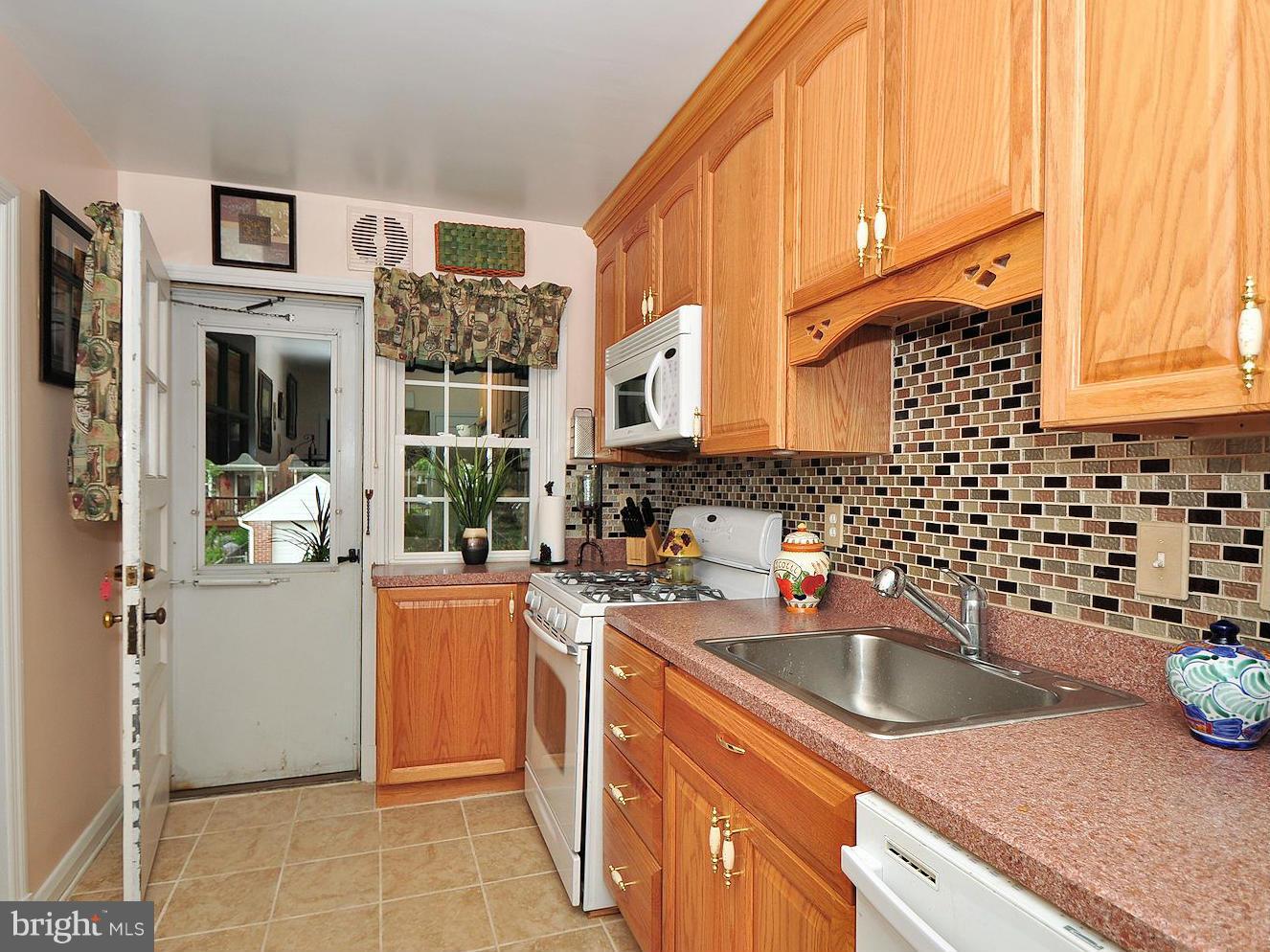 104 Overbrook Road Baltimore, MD 21212 - Photo 6 of 27 a kitchen with stainless steel appliances a sink a stove a refrigerator cabinets and a window