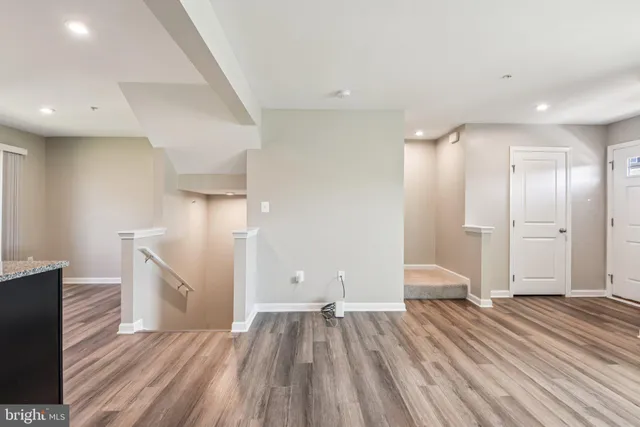 a view of empty room with wooden floor