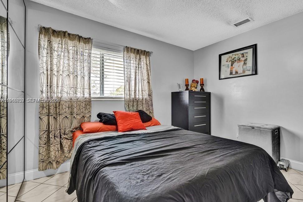 19821 Eagle Nest Road Cutler Bay, FL 33157 - Photo 15 of 23 a bedroom with a bed and a dresser