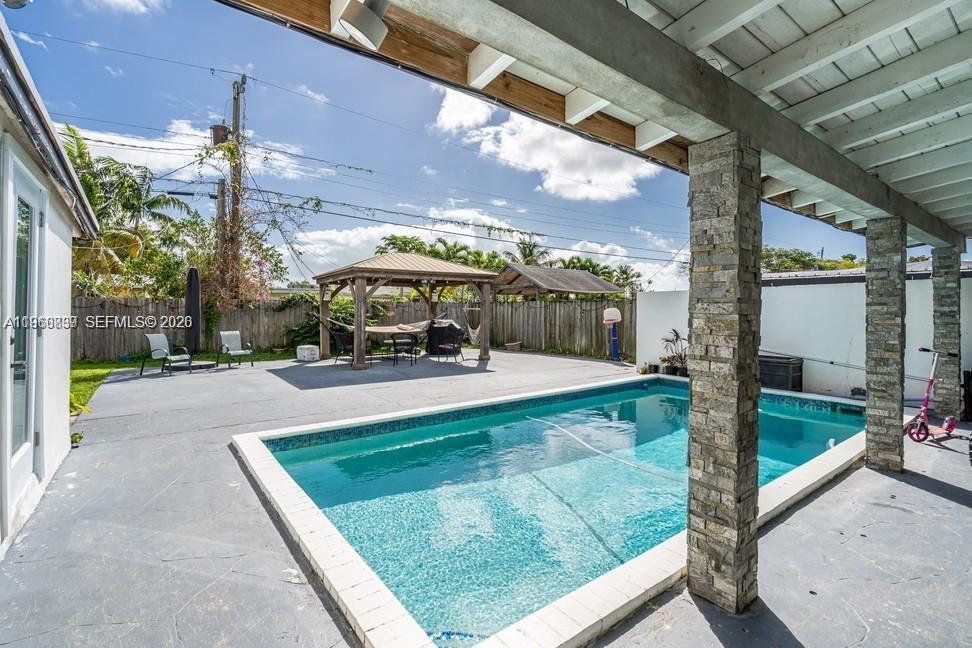 19821 Eagle Nest Road Cutler Bay, FL 33157 - Photo 20 of 23 a view of a patio with table and chairs potted plants with wooden floor