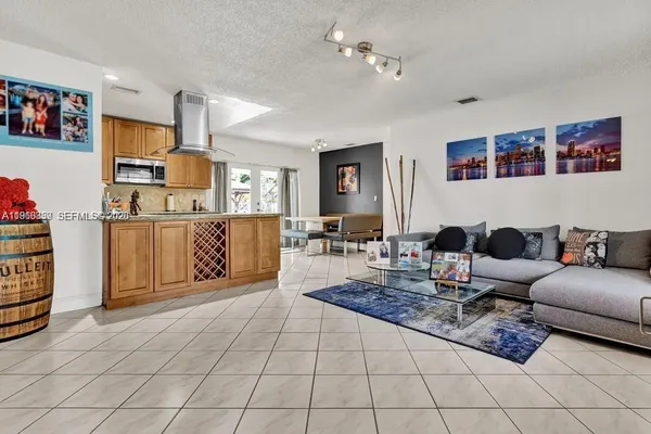 a living room with furniture a flat screen tv and kitchen view