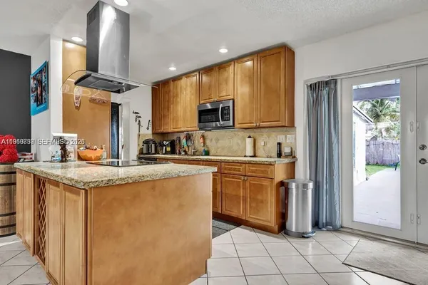 a kitchen with stainless steel appliances granite countertop a sink and a refrigerator
