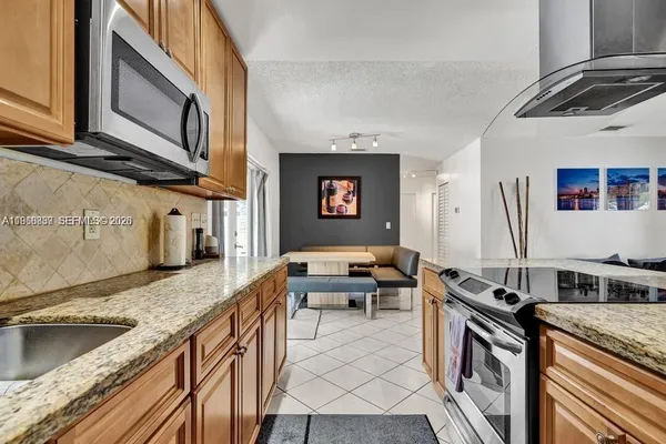 a kitchen with stainless steel appliances granite countertop a sink and a stove