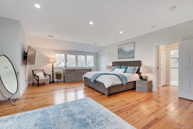 a spacious bedroom with a bed a couch and dresser