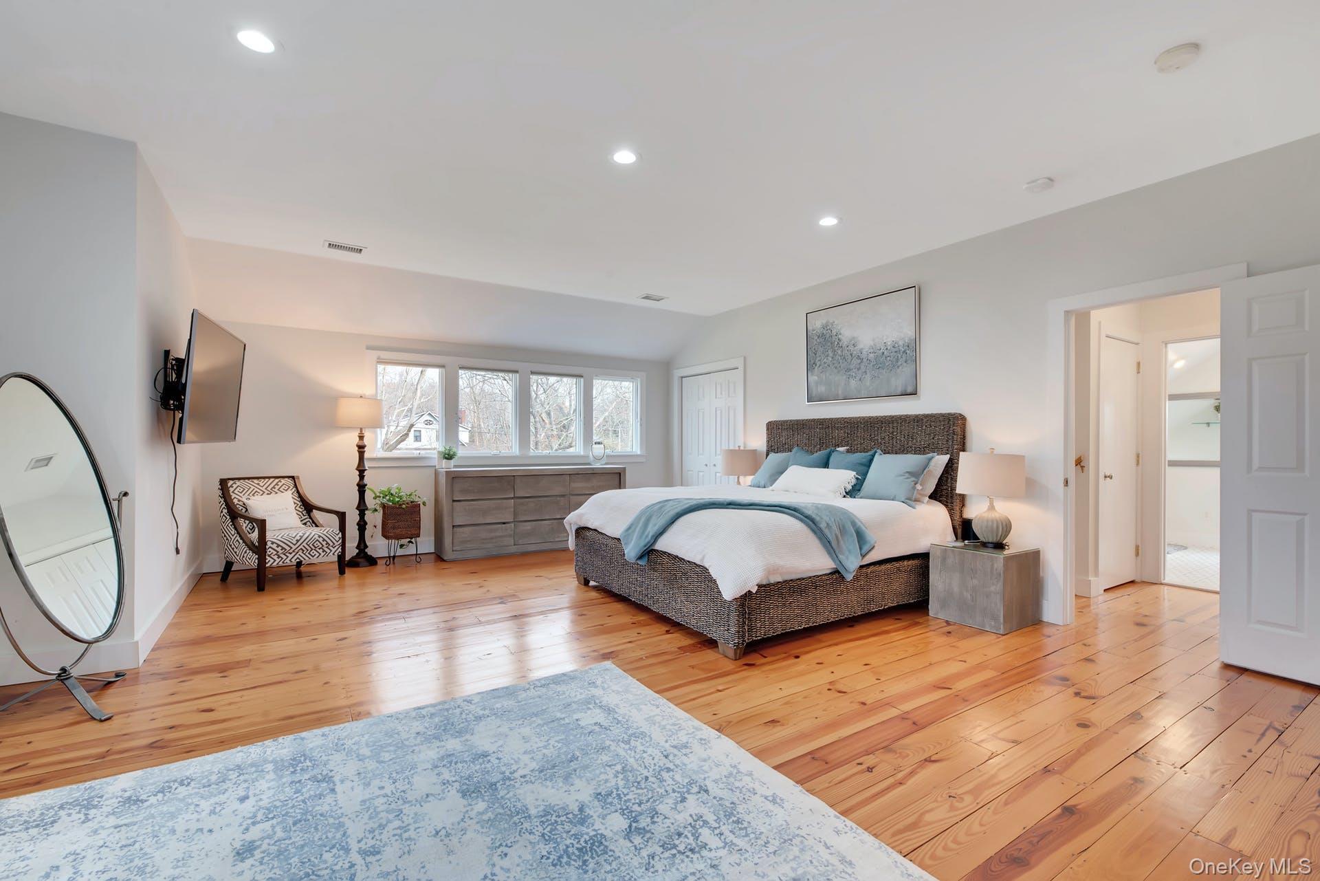 550 Krause Road Mattituck, NY 11952 - Photo 14 of 34 a spacious bedroom with a bed a couch and dresser