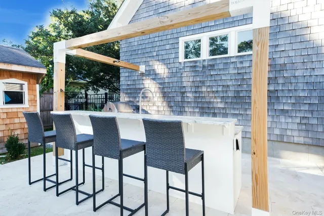 a patio with table and chairs and potted plants
