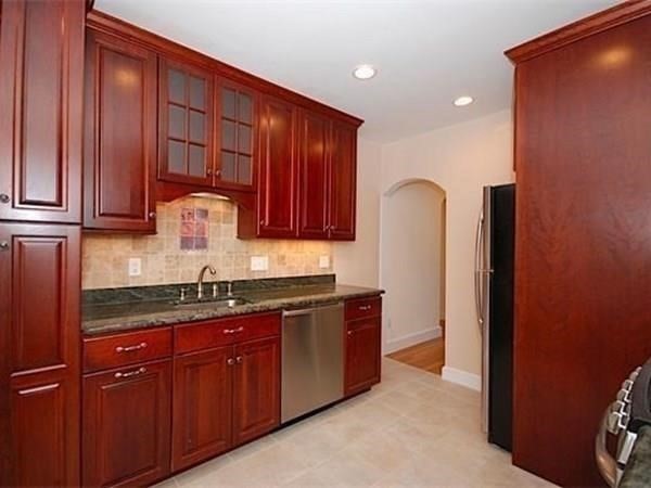 a kitchen with stainless steel appliances granite countertop wooden cabinets and a sink