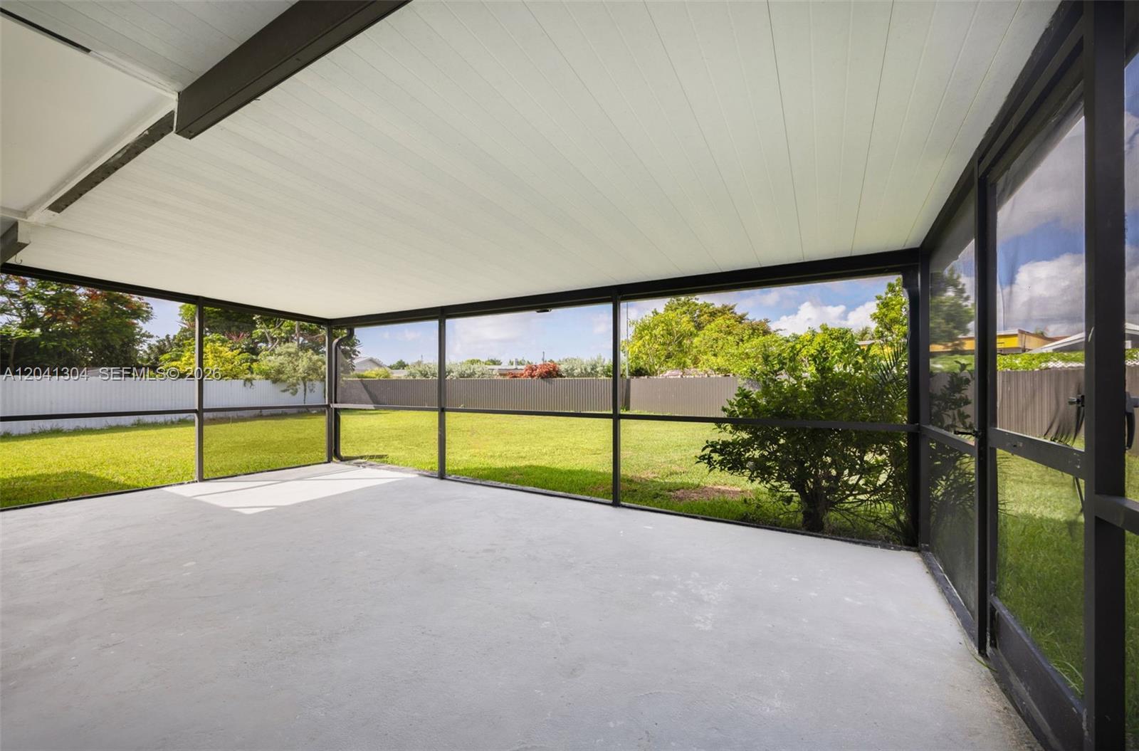 10340 Southwest 157th Street Miami, FL 33157 - Photo 17 of 24 Screened Patio – Expansive screened-in patio offering the perfect space for outdoor dining, entertaining, or relaxing while enjoying backyard views. Covered design provides year-round enjoyment.