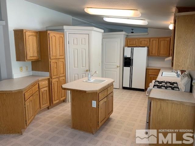 14990 Kivett Lane Reno, NV 89521 - Photo 4 of 16 a kitchen with a stove a refrigerator and a sink
