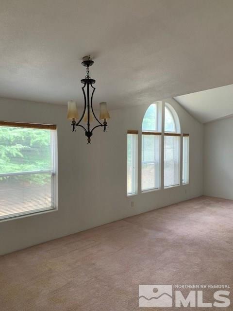 14990 Kivett Lane Reno, NV 89521 - Photo 6 of 16 an empty room with windows and chandelier