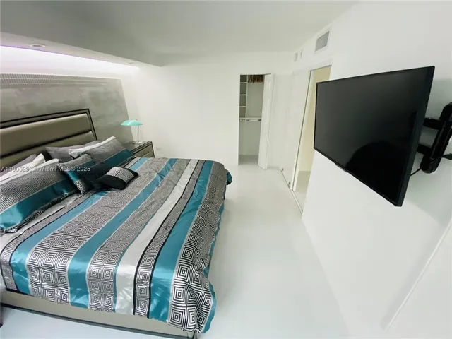 a bedroom with a bed and flat screen tv
