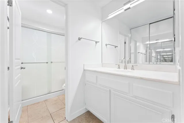 a bathroom with a double vanity sink mirror and shower