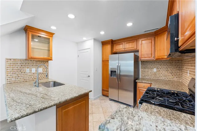 a kitchen with granite countertop a sink and a refrigerator