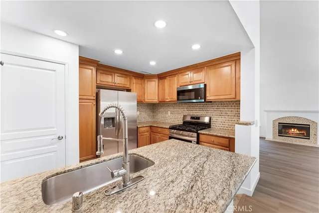 a kitchen with stainless steel appliances granite countertop a sink stove and refrigerator