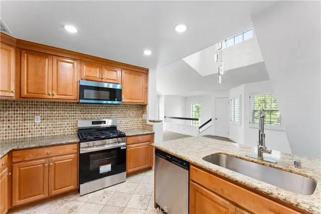 a kitchen with granite countertop a sink and steel appliances
