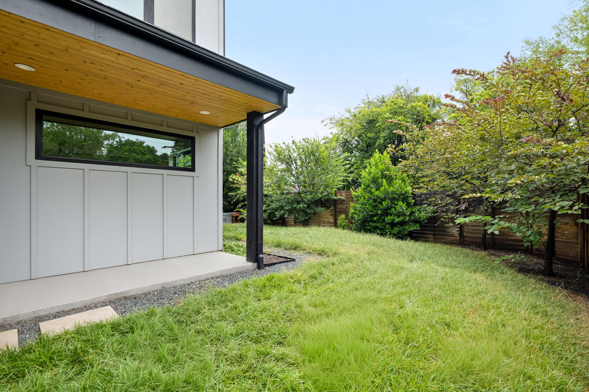 3508 Lyons Road Austin, TX 78702 - Photo 33 of 40 A private, grassy yard bordered by a wooden fence and lush trees provides a serene outdoor escape.