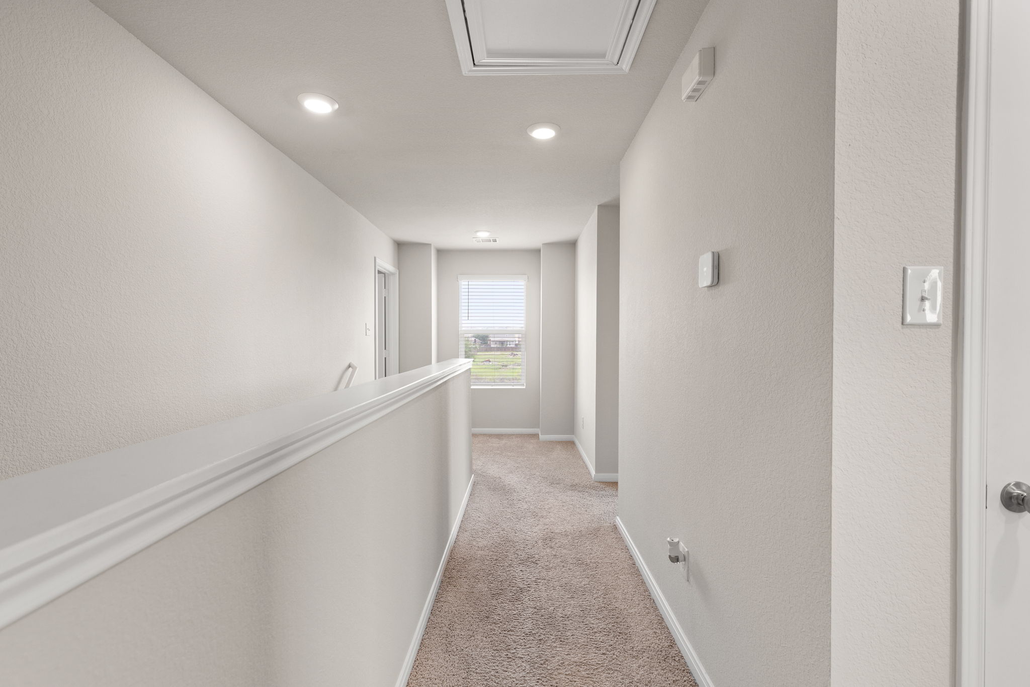 281 Jayden Drive Kyle, TX 78640 - Photo 20 of 36 Carpeted hallway featuring a window with horizontal blinds, recessed lighting, white trim, and a white interior door