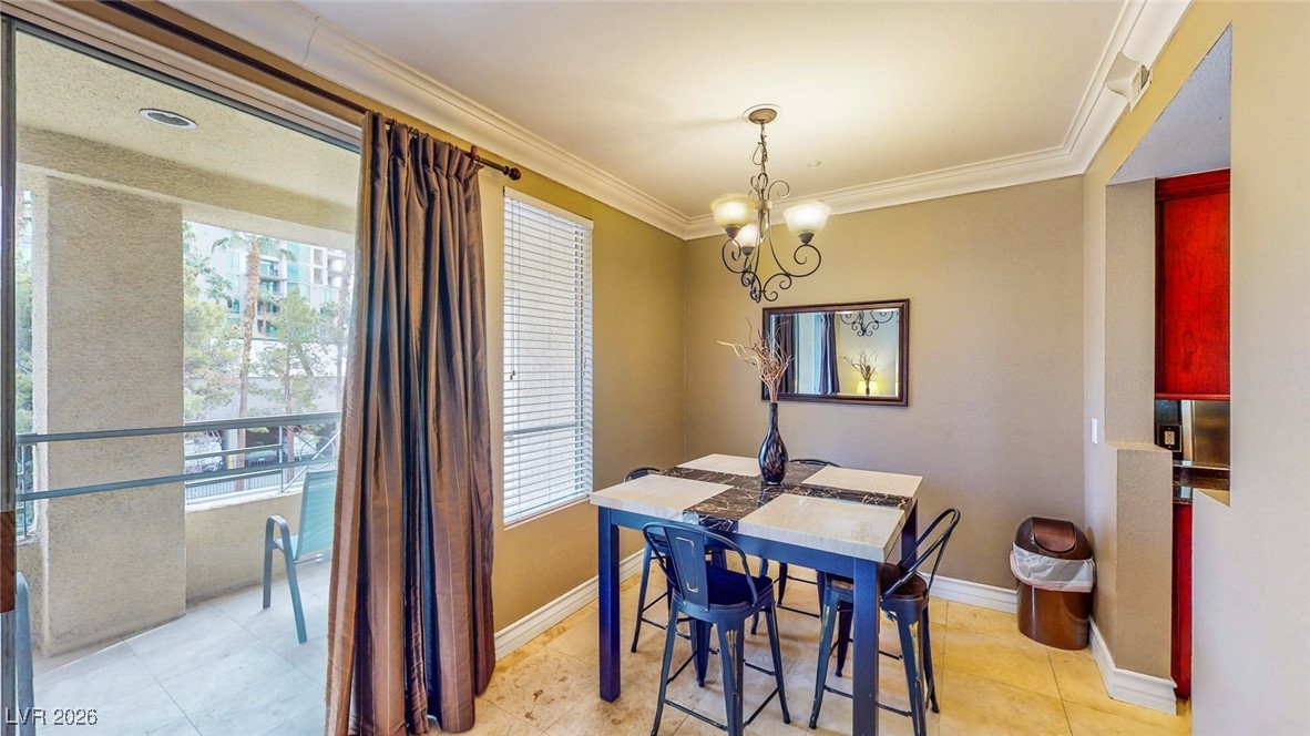 260 East Flamingo Road, Unit 229 Las Vegas, NV 89169 - Photo 21 of 31 Dining space with suspended lighting, crown molding, plenty of natural light, and light tile patterned floors
