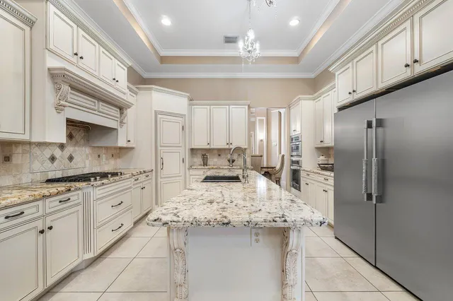 a kitchen with stainless steel appliances granite countertop a stove top oven a refrigerator a sink dishwasher and white cabinets with wooden floor