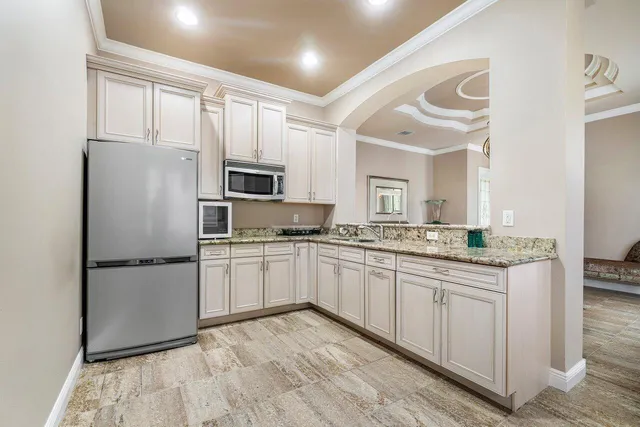 a dining room with wooden floor a chandelier a glass table and chairs