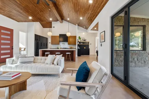 a living room with fireplace furniture and a floor to ceiling window