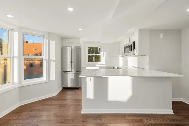 a view of a kitchen with stainless steel appliances granite countertop a refrigerator and cabinets