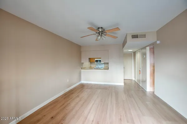 a view of a big room with wooden floor and a ceiling fan