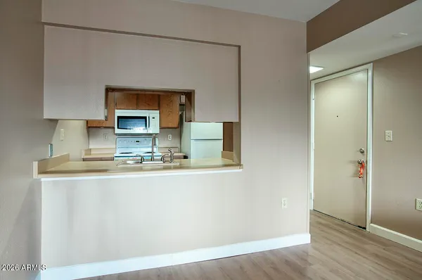 a view of kitchen with stainless steel appliances granite countertop a sink and a refrigerator
